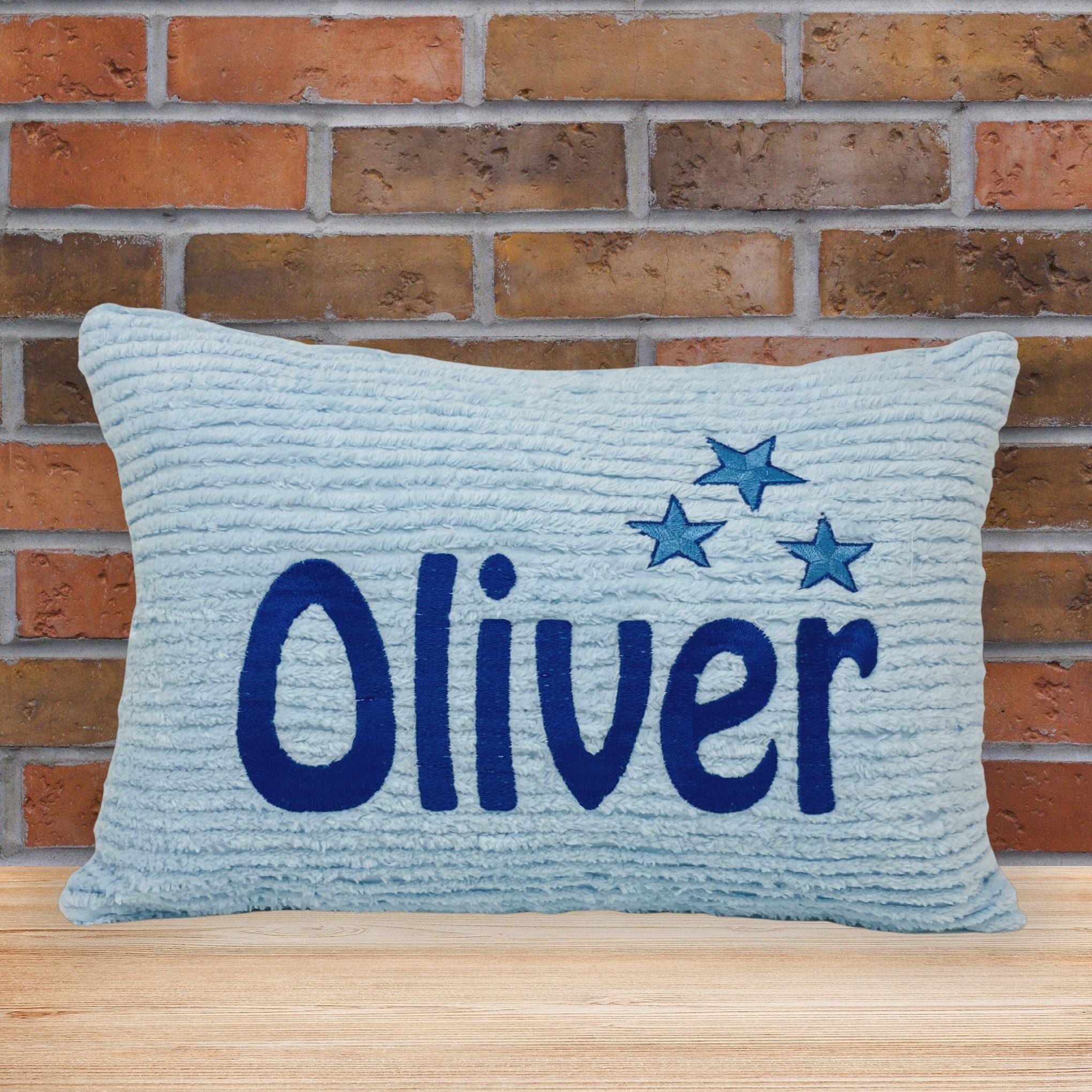 Blue chenille pillow with embroidered name and stars. Personalized gift idea