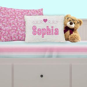 Chenille name pillow for girl, pink applique with heart on bed
